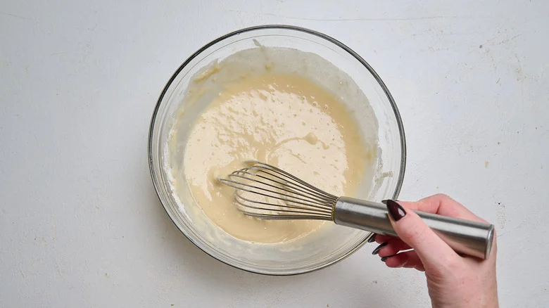 whisking wet ingredients into dry batter