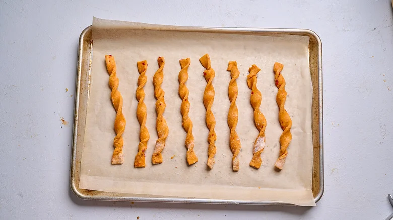 dough strips twisted into straws on a sheet tray