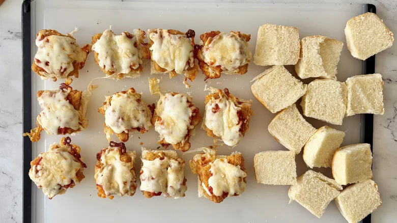 Chicken parmesan sliders next to top buns