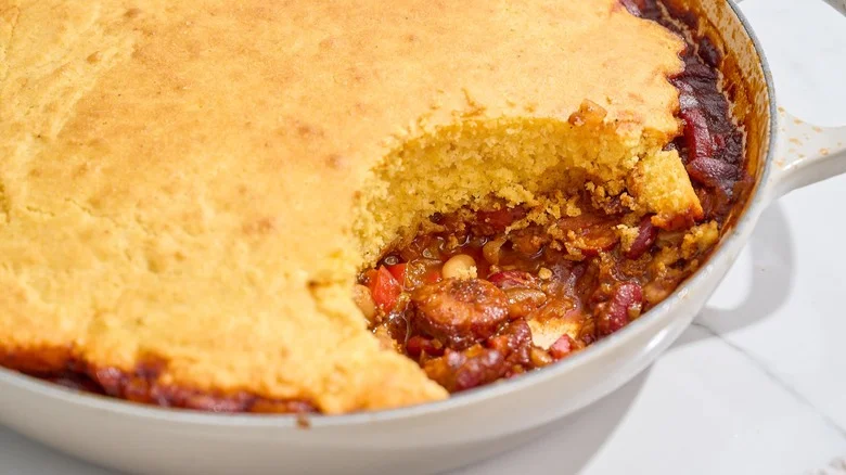 beanie weenie casserole with cornbread topping in a skillet