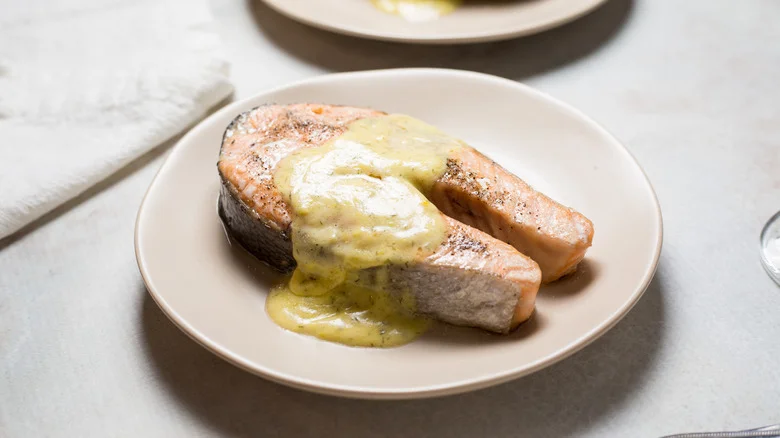salmon steak with sauce served on table