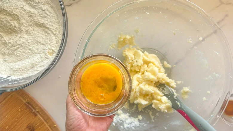 hand adding beaten egg