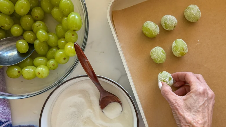 hand putting rolled grape on pan