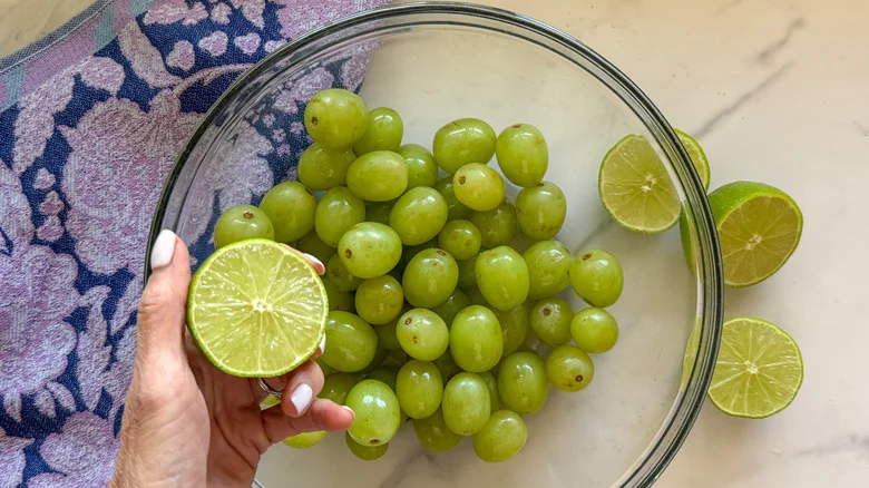 hand holding lime over grapes