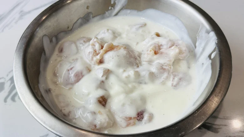 Chicken in bowl coated with buttermilk