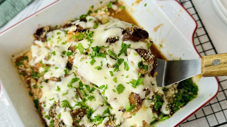 chicken with mushrooms and cheese in a white pan