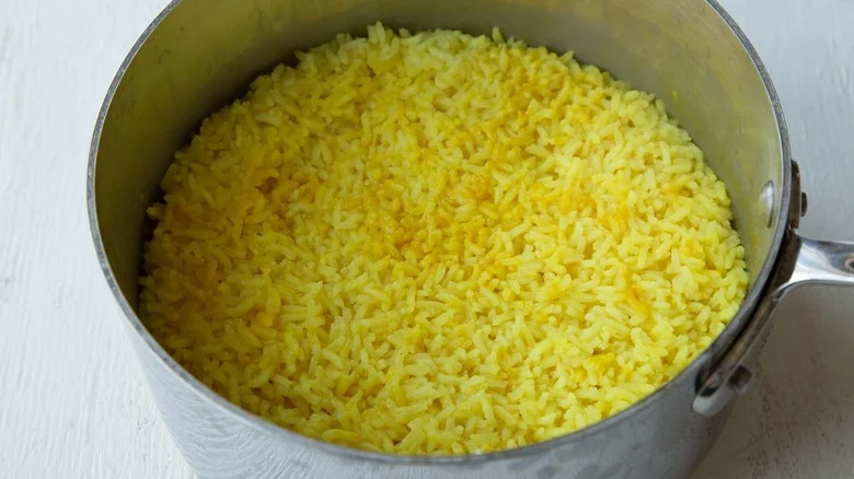 turmeric rice cooking in saucepan