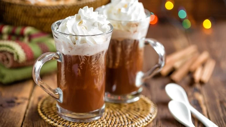 Two frangelicocoa cocktails in glass mugs, topped with whipped cream
