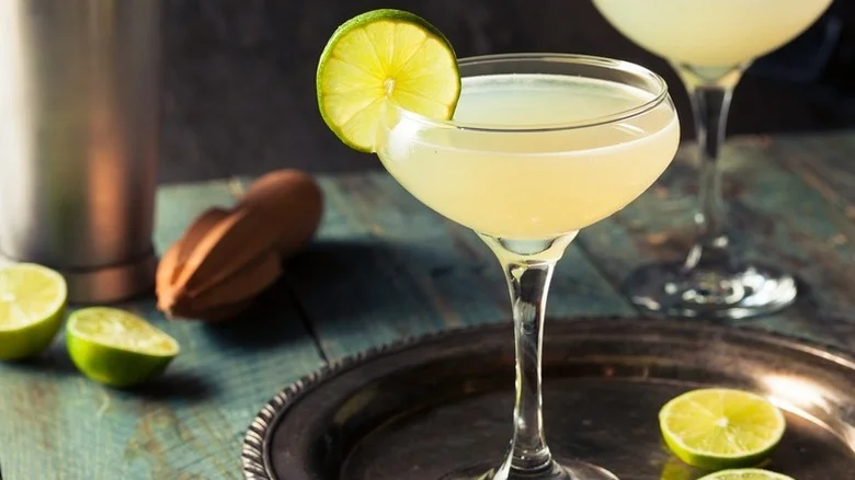 Two daiquiris in coupe glasses, garnished with lime wheels