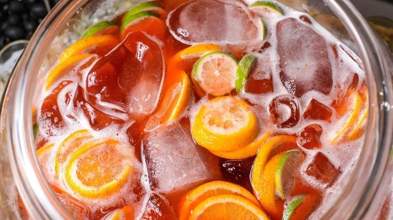 Closeup of a very merry crush cocktail showing ice cubes and citrus slices