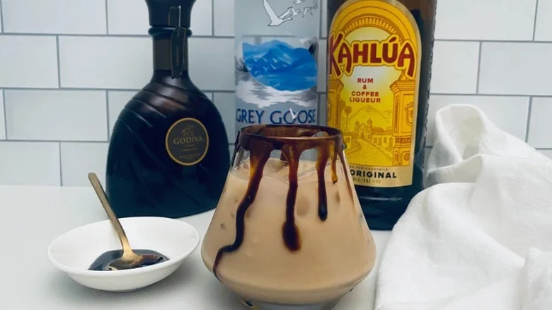 A mocha-style white Russian in a glass decorated with a chocolate syrup rim