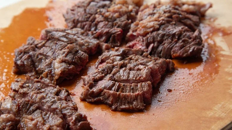 Sliced cooked steak on cutting board