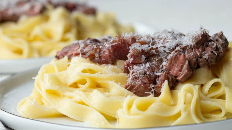 Side view of steak Alfredo pasta