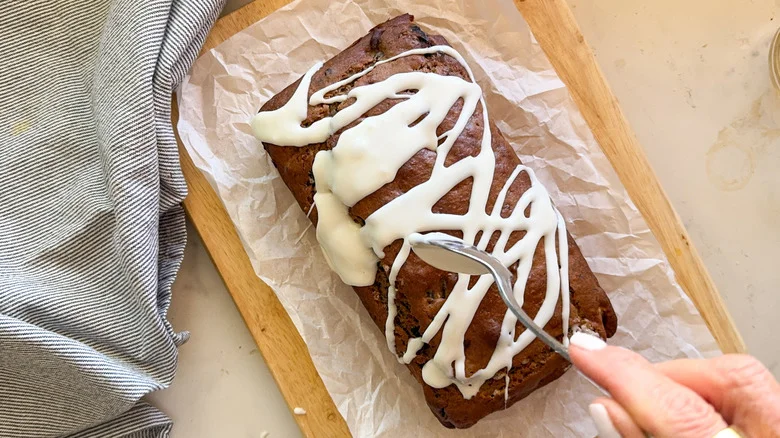 spooning glaze over banana bread loaf