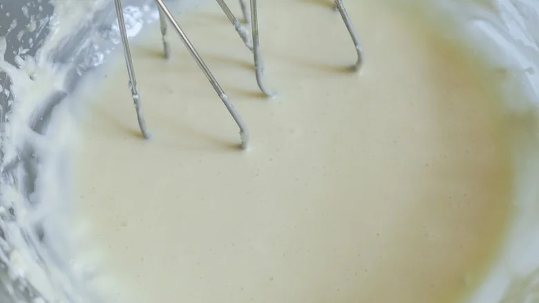 Cheesecake batter in bowl with mixers