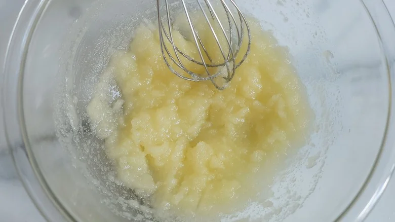 Melted butter and sugar mixture with whisk in bowl
