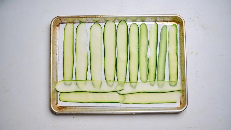 salted zucchini on paper-towel lined sheet tray