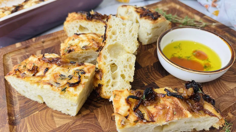 Slices of caramelized onion focaccia with bowl of oil