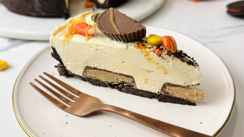 Slice of Halloween candy cheesecake on plate with fork