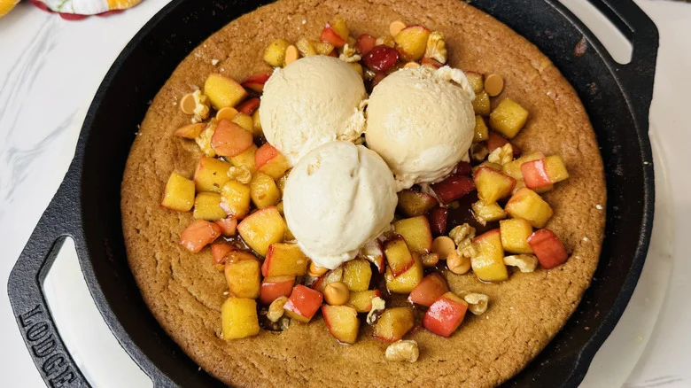 Apple blondie skillet topped with spiced apples and vanilla ice cream scoops