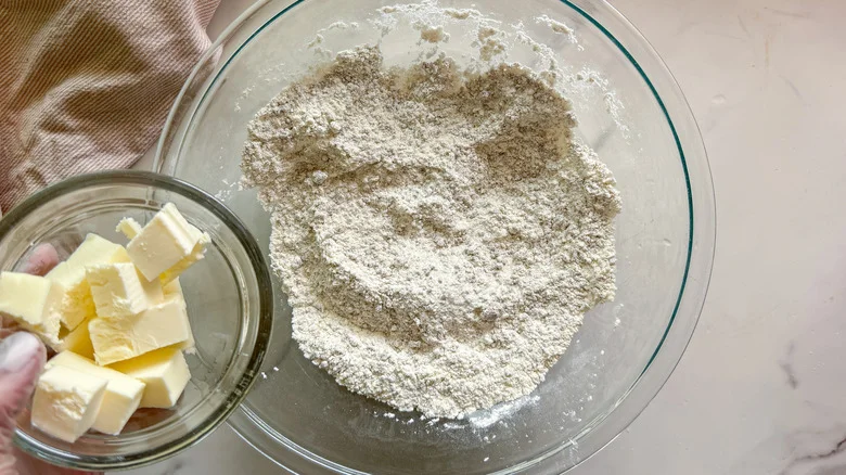 hand adding butter to bowl