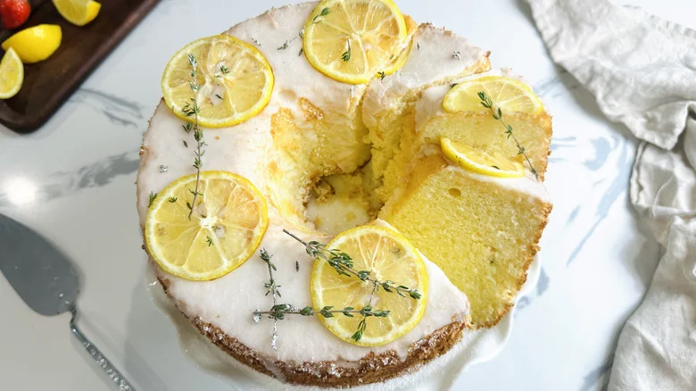 Lemon thyme chiffon cake on cake stand with slices cut