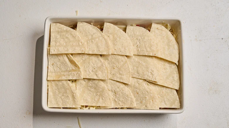 tortillas arranged across the top of the casserole dish