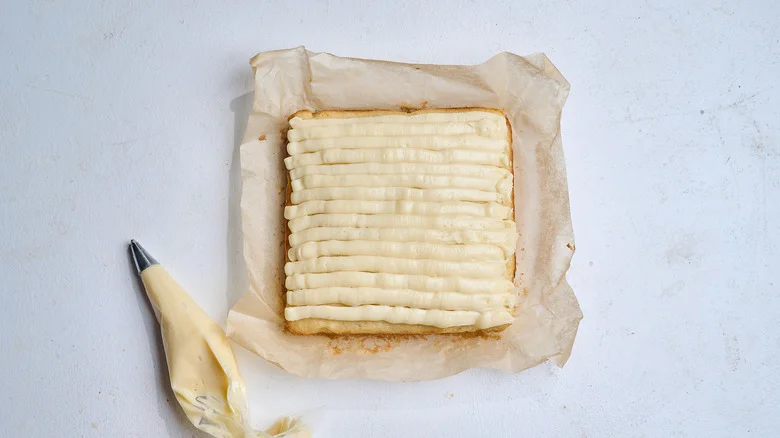 frosting the cake with a piping bag