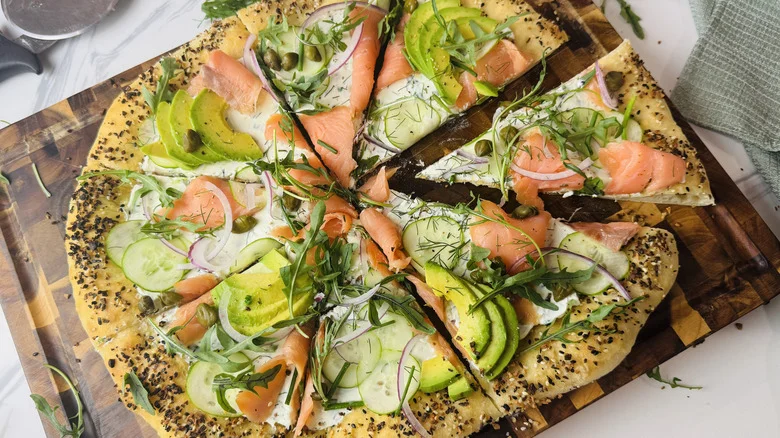Bagels and lox inspired pizza on wooden board