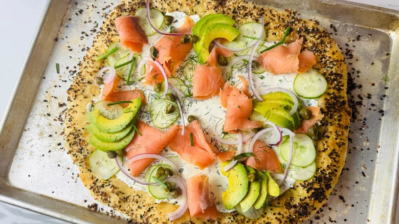 Bagels and lox inspired pizza on baking sheet