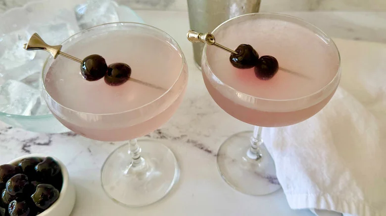 Two Aviation cocktails garnished with cherry skewers