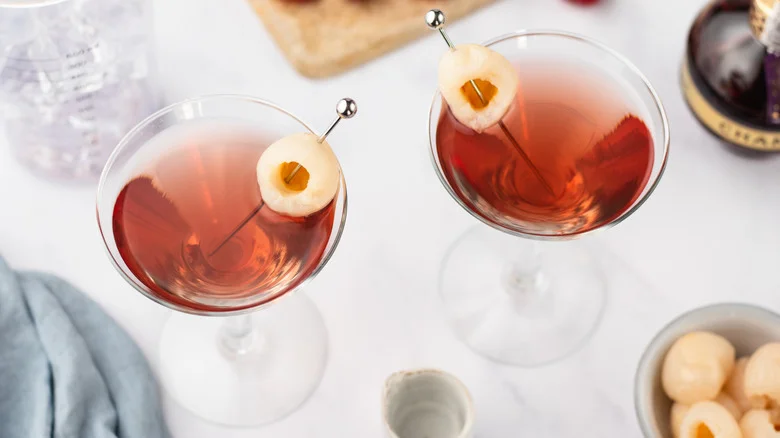 Two raspberry lychee martinis with whole lychee garnishes