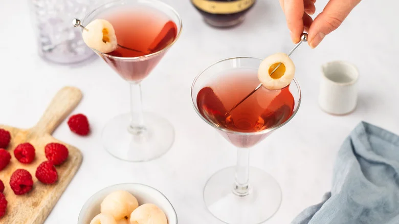Placing lychee garnish into raspberry lychee martini