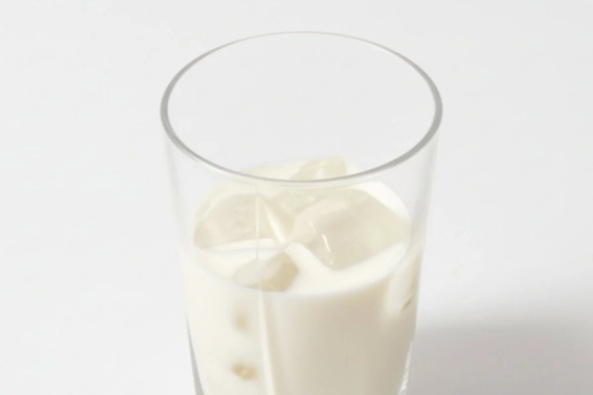 pour cold milk into the glass and add ice